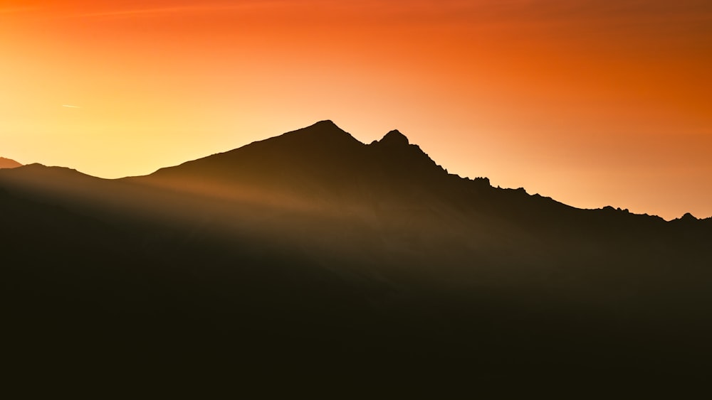 silhouette of mountain during sunset