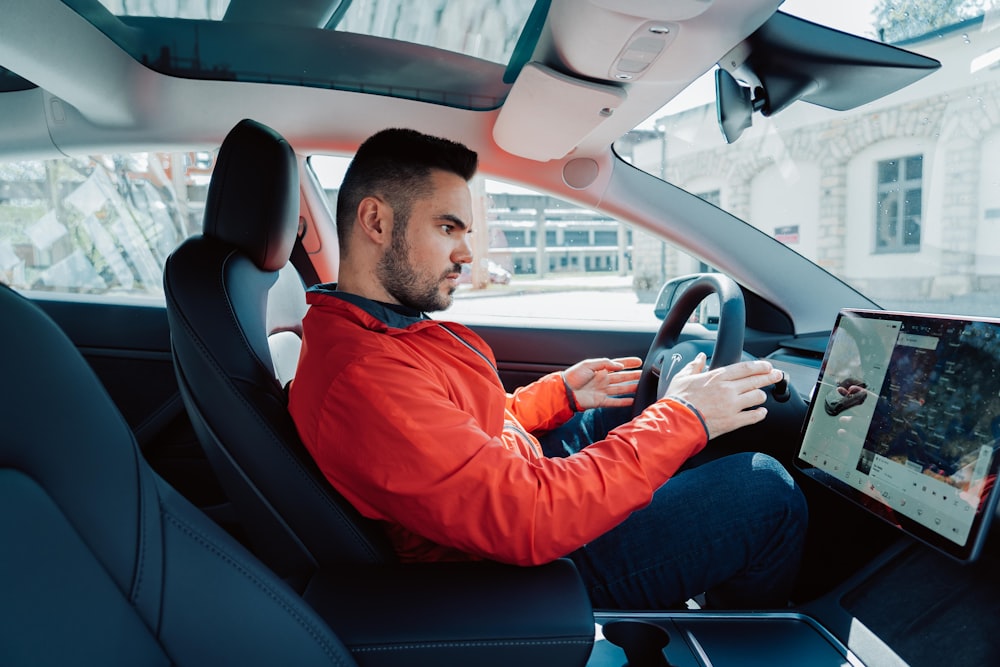 man in red long sleeve shirt driving car