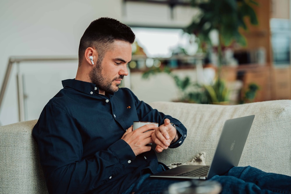 man in black dress shirt holding black smartphone