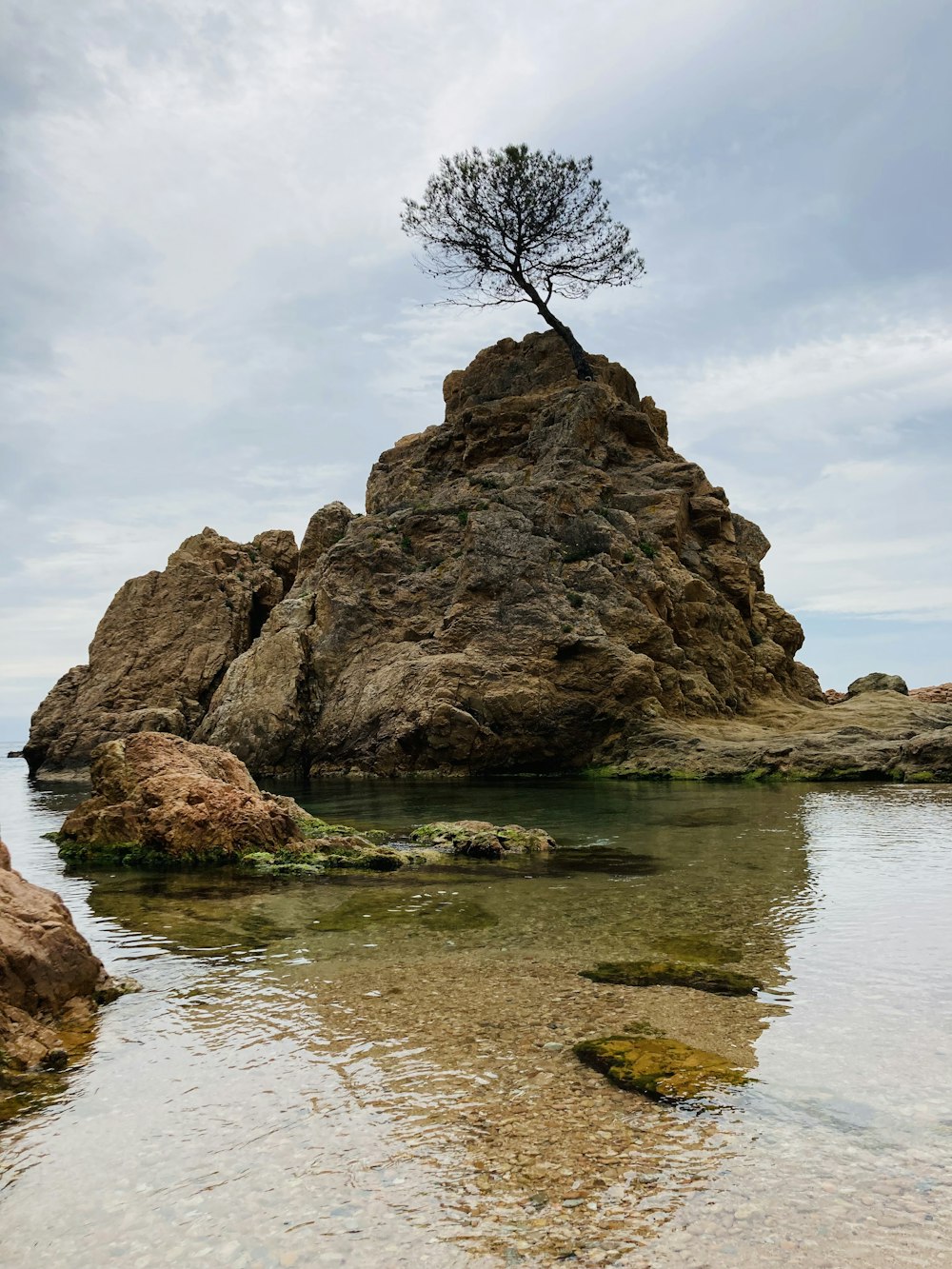 brown rock formation on body of water during daytime