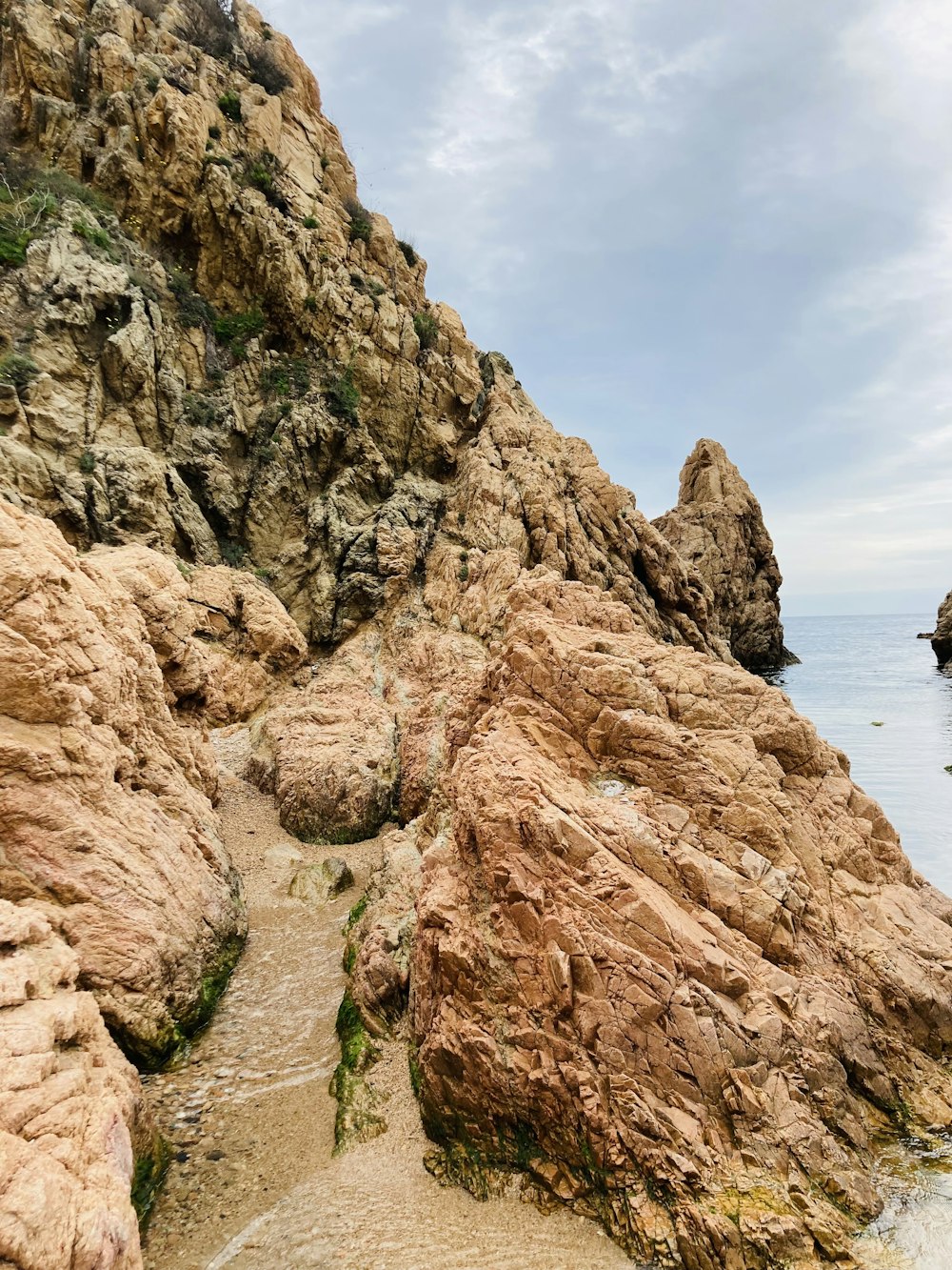 brown rock formation near body of water during daytime