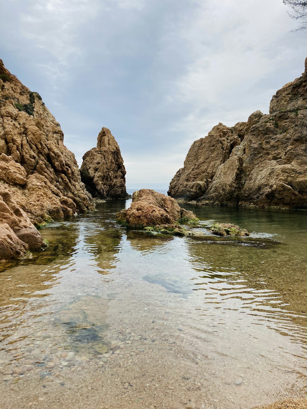 brown rock formation on body of water during daytime