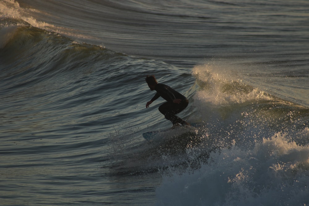 man surfing on sea waves during daytime