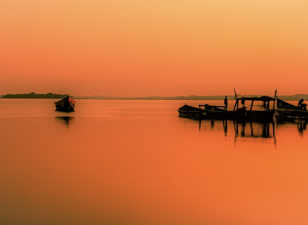 silhouette of people riding boat on sea during daytime