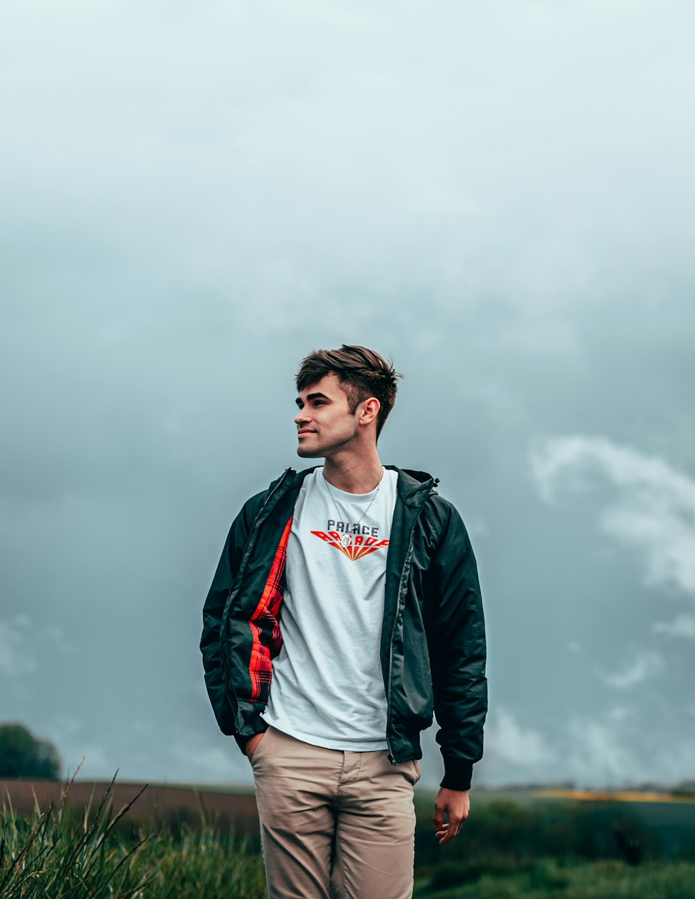 man in black jacket standing on field