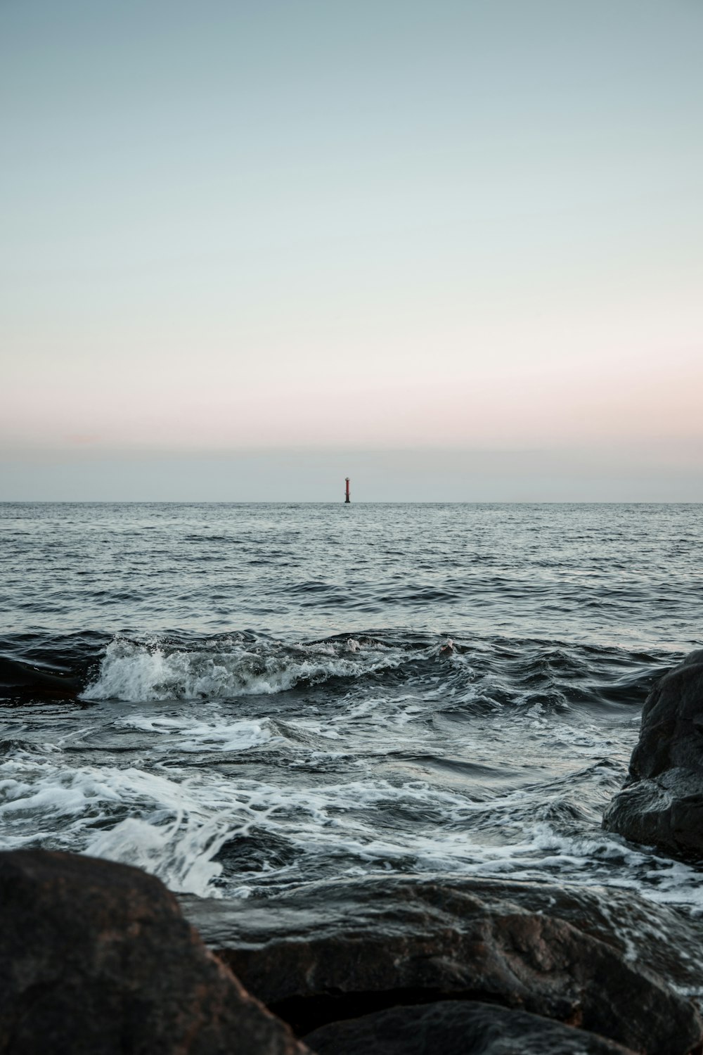 person standing on rock near sea during daytime