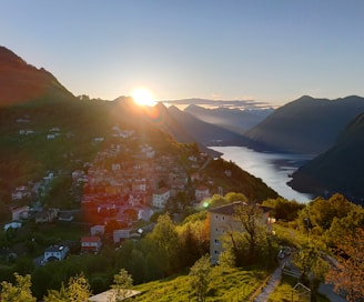 Scenic landscape showcasing a vibrant sunrise over a peaceful village, reflecting the essence of folivotourism's travel stories.