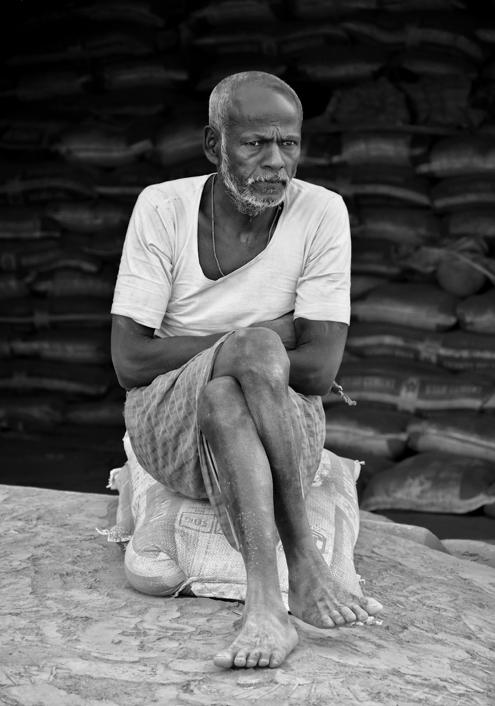 man in white crew neck t-shirt sitting on ground