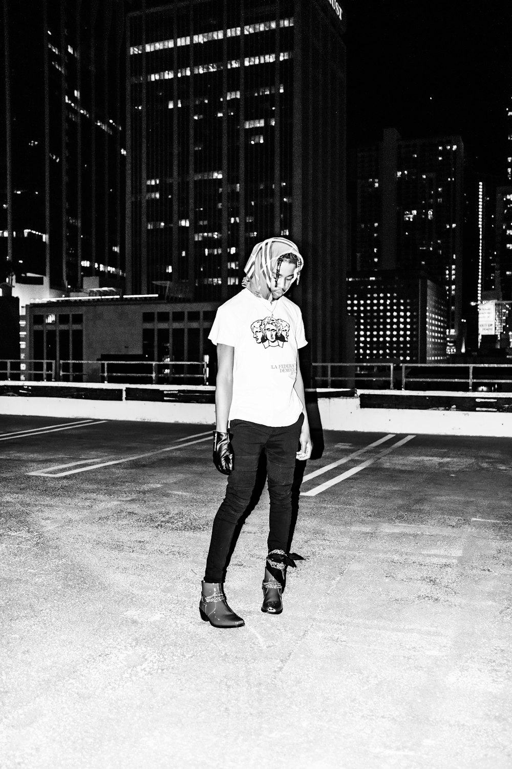 grayscale photo of woman in white long sleeve shirt and black pants standing on basketball court