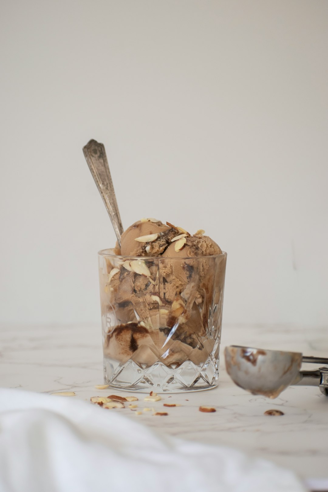 ice cream on clear glass cup beside stainless steel spoon