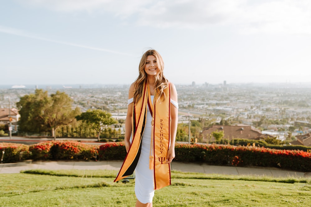 woman in brown coat standing on green grass field during daytime