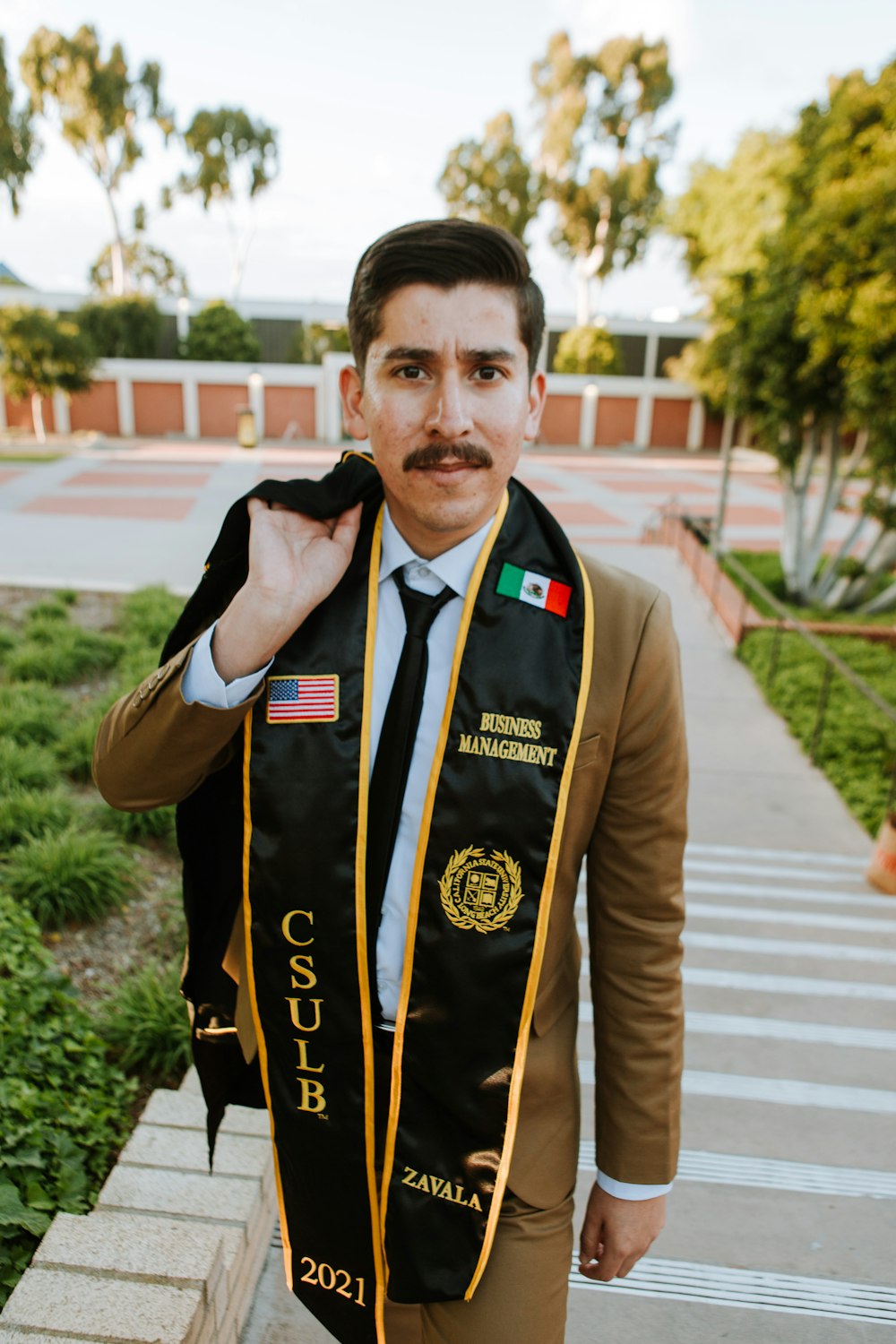 man in brown and black uniform standing on sidewalk during daytime