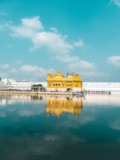 white and brown concrete building near body of water under blue sky during daytime