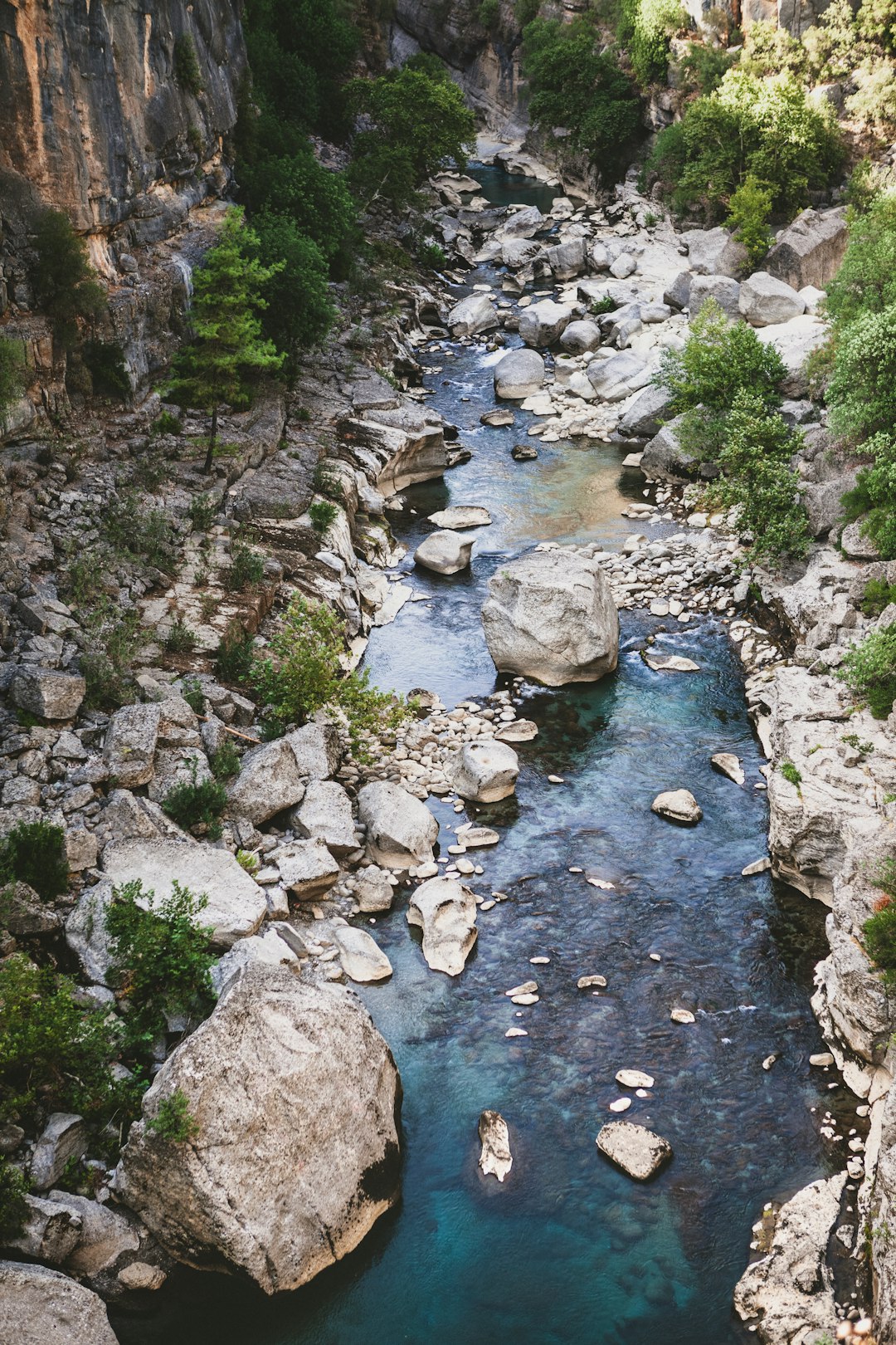 river in between rocky mountain during daytime