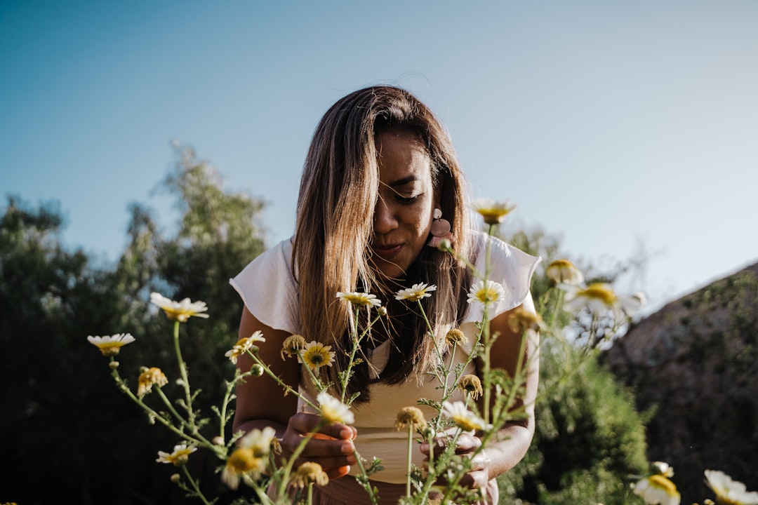 woman in white shirt holding white flowers