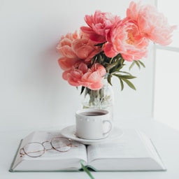 pink flowers on white ceramic mug on white ceramic saucer