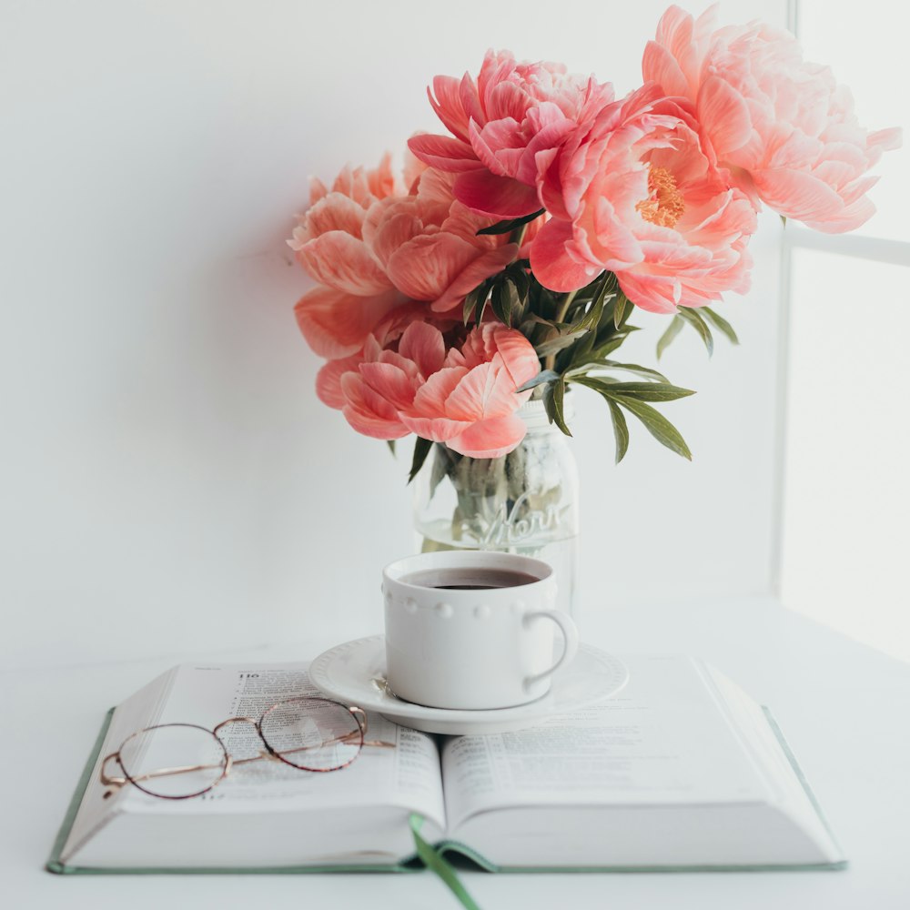 pink flowers on white ceramic mug on white ceramic saucer