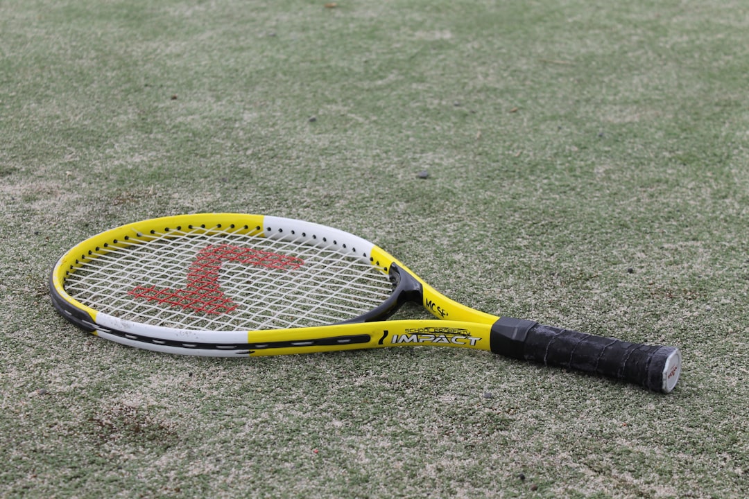 yellow and black tennis racket on green grass field