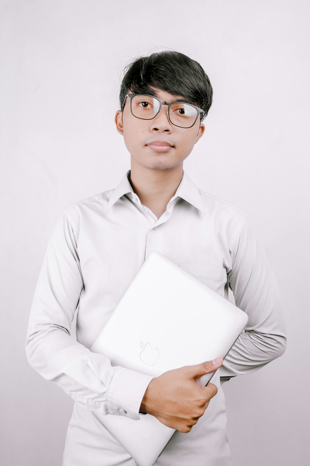 man in white dress shirt holding white printer paper
