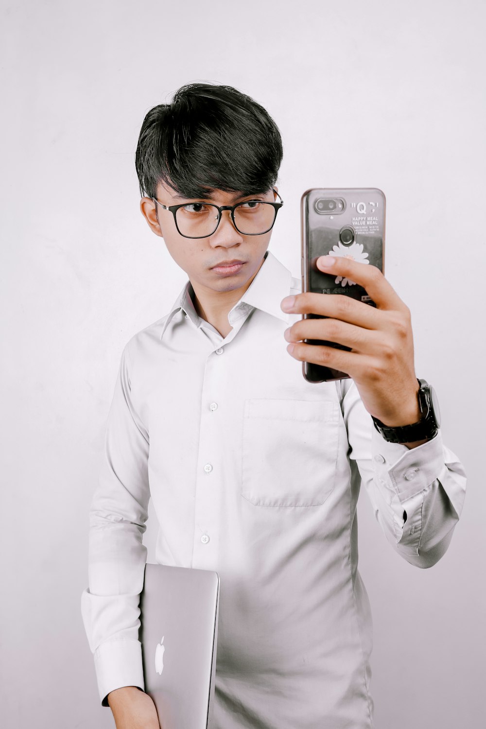 man in white dress shirt holding iphone