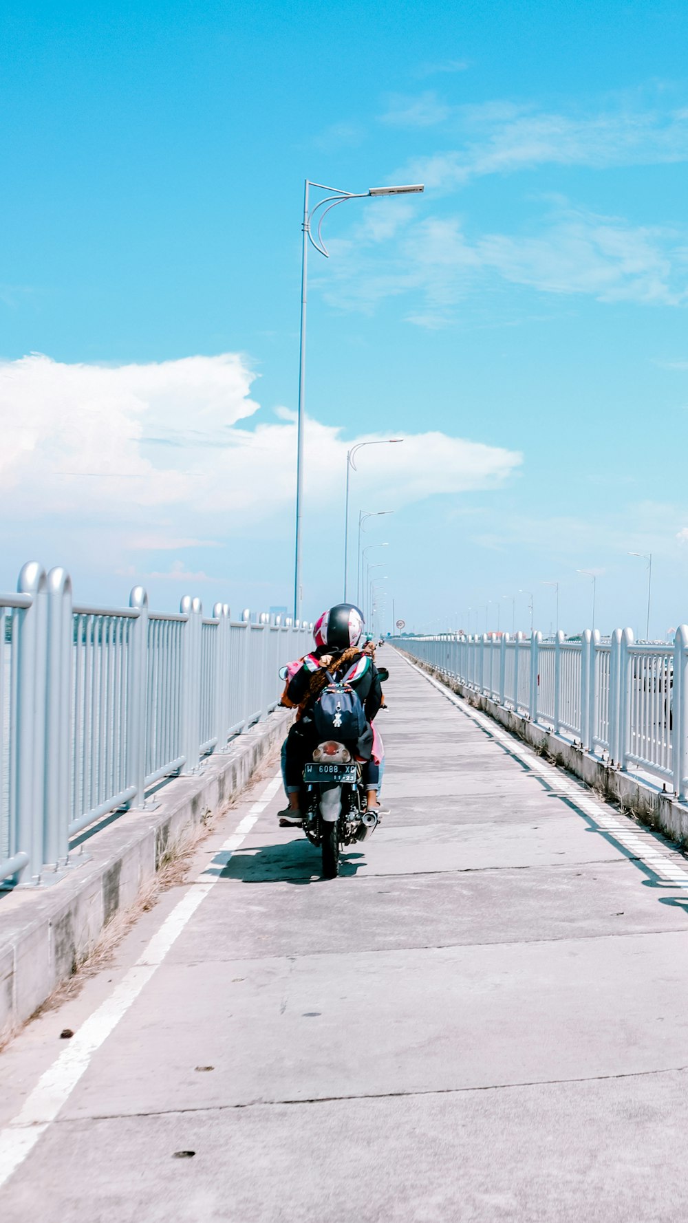 man in black jacket riding motorcycle on road during daytime