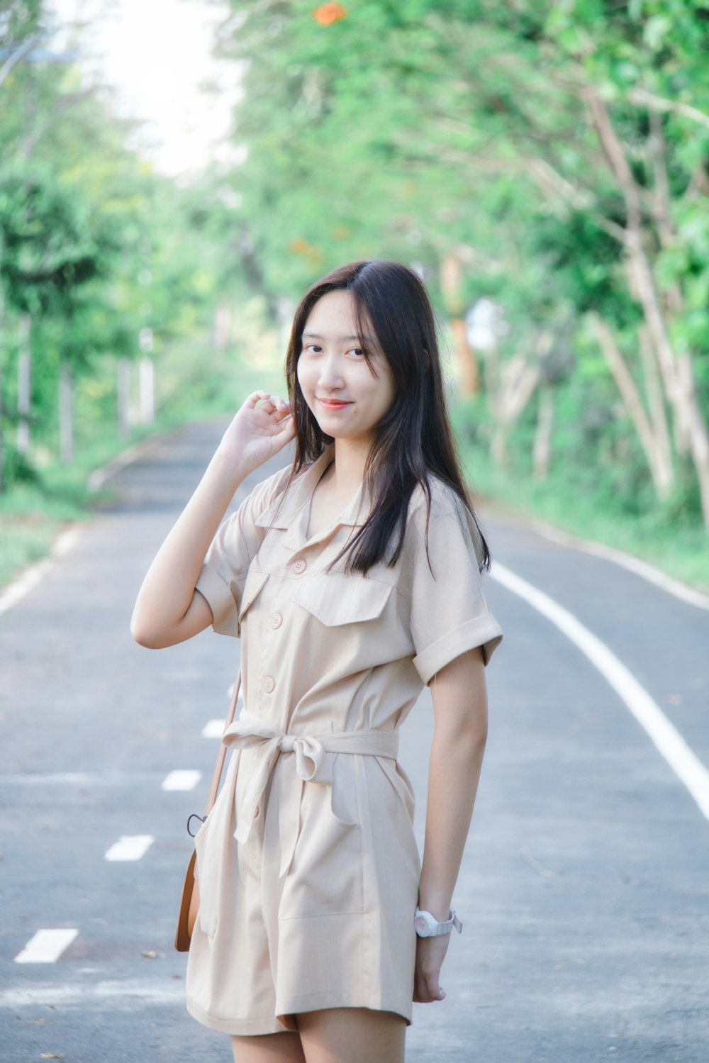 woman in brown sleeveless dress standing on road during daytime