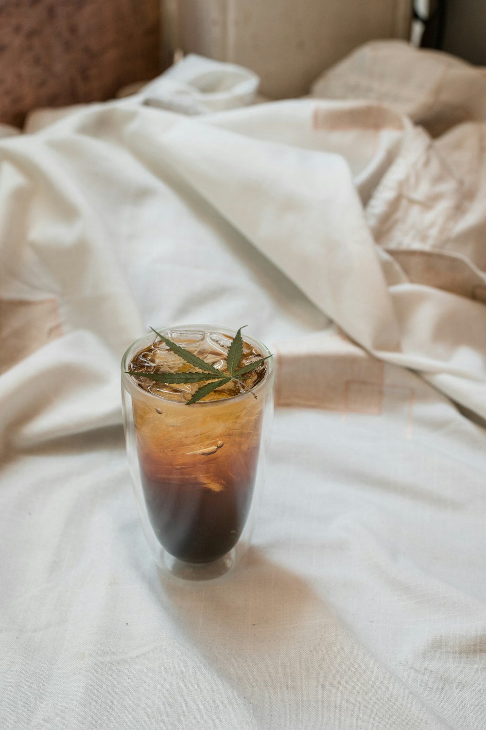 clear drinking glass with brown liquid and ice