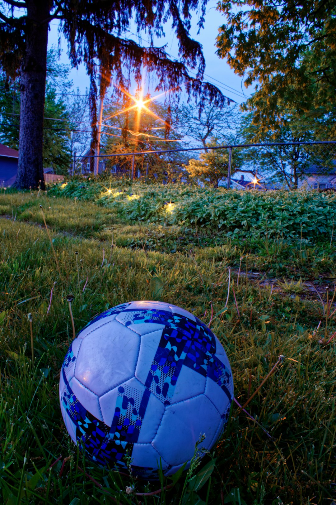 white and black soccer ball on green grass field during sunset
