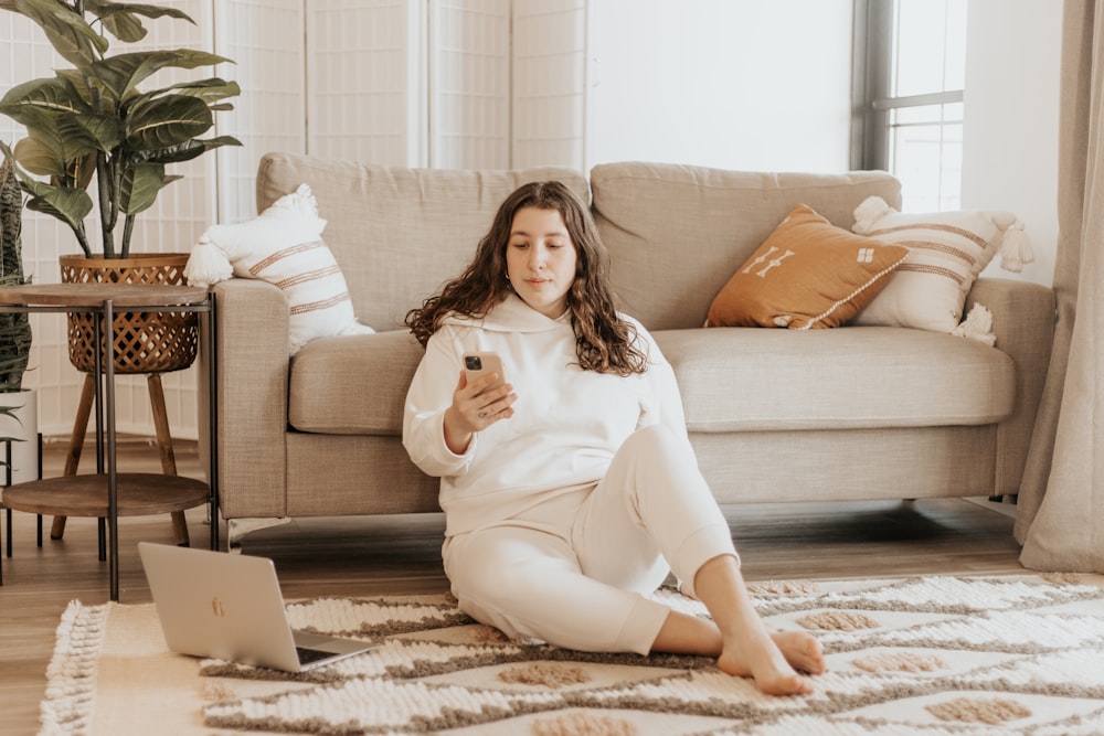 woman in white long sleeve dress sitting on brown and white area rug