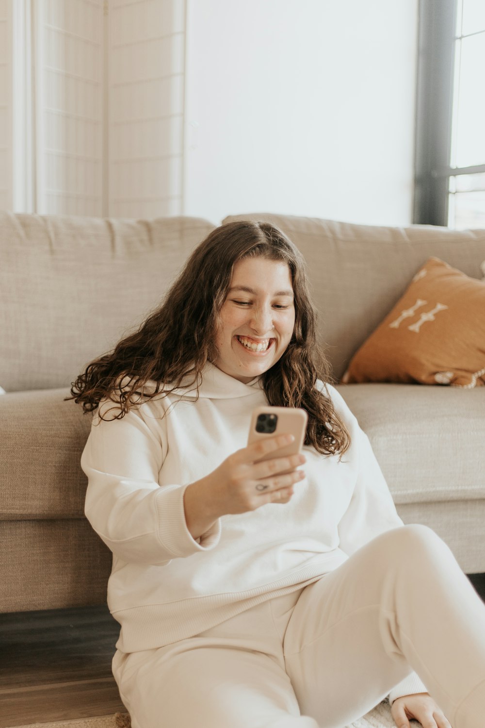 woman in white long sleeve shirt holding iphone