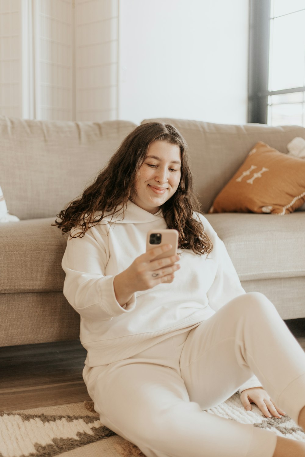 woman in white long sleeve shirt sitting on couch