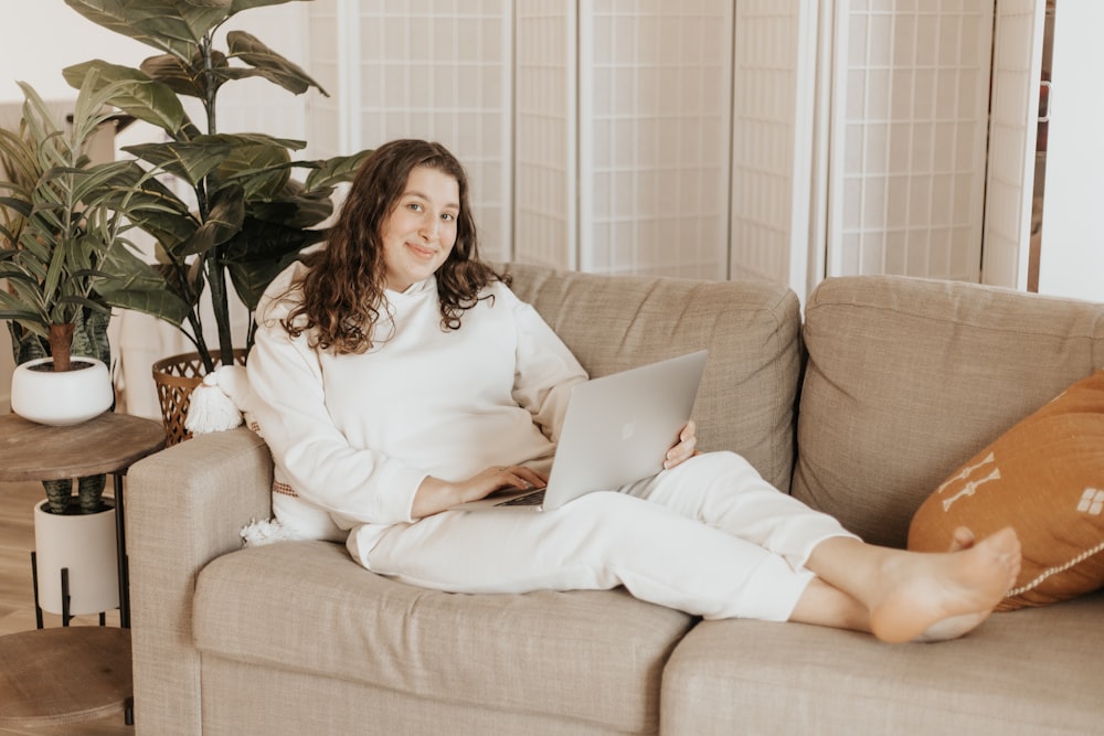 woman in white long sleeve dress sitting on brown couch