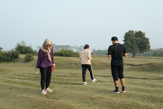 3 men and 2 women standing on green grass field during daytime
