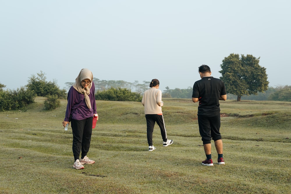 3 men and 2 women standing on green grass field during daytime