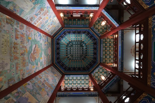 Artistic ceiling design with colorful murals and intricate plasterwork.