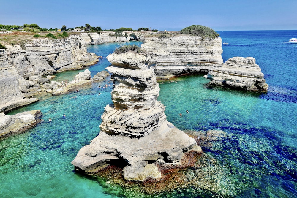 gray rock formation on body of water during daytime