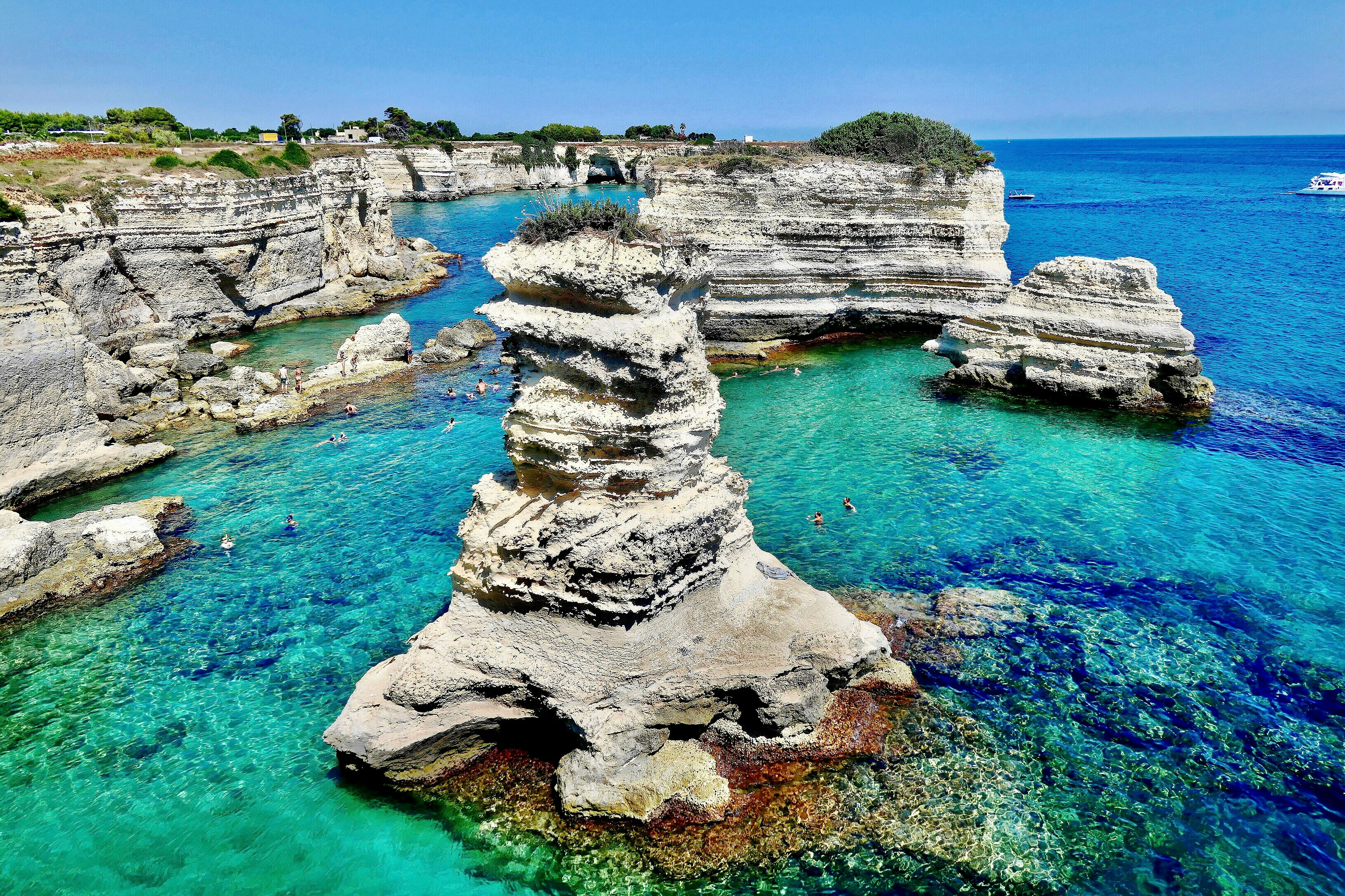 gray rock formation on body of water during daytime