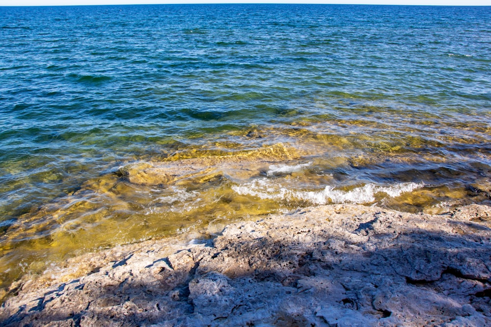 brown rock formation on body of water during daytime