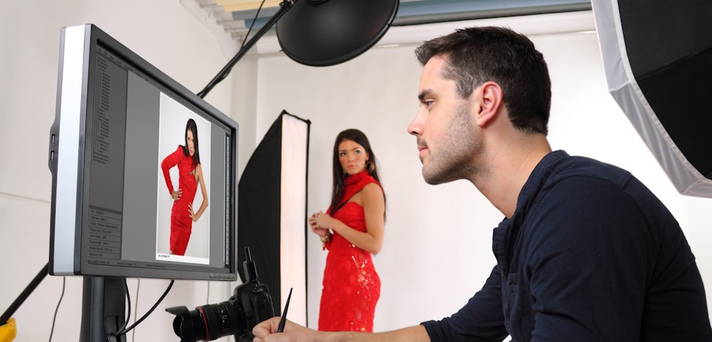 man in black dress shirt holding woman in red sleeveless dress