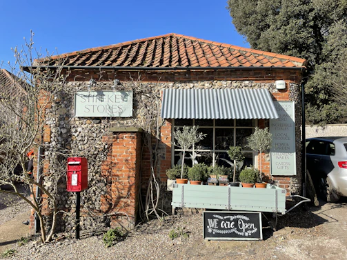 A friendly shop front of a local post factory with a visible WhatsApp contact number.