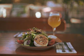 A glass of local Austrian white wine beside a plate of seasonal salad.