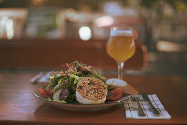 A glass of local Austrian white wine beside a plate of seasonal salad.
