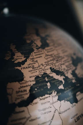 A close-up view of a globe focusing on Europe and parts of North Africa. Countries such as France, Spain, Italy, and Tunisia are visible with their names prominently printed. Various cities like Paris, Rome, and Lyon are also marked, along with geographical borders and coastlines.