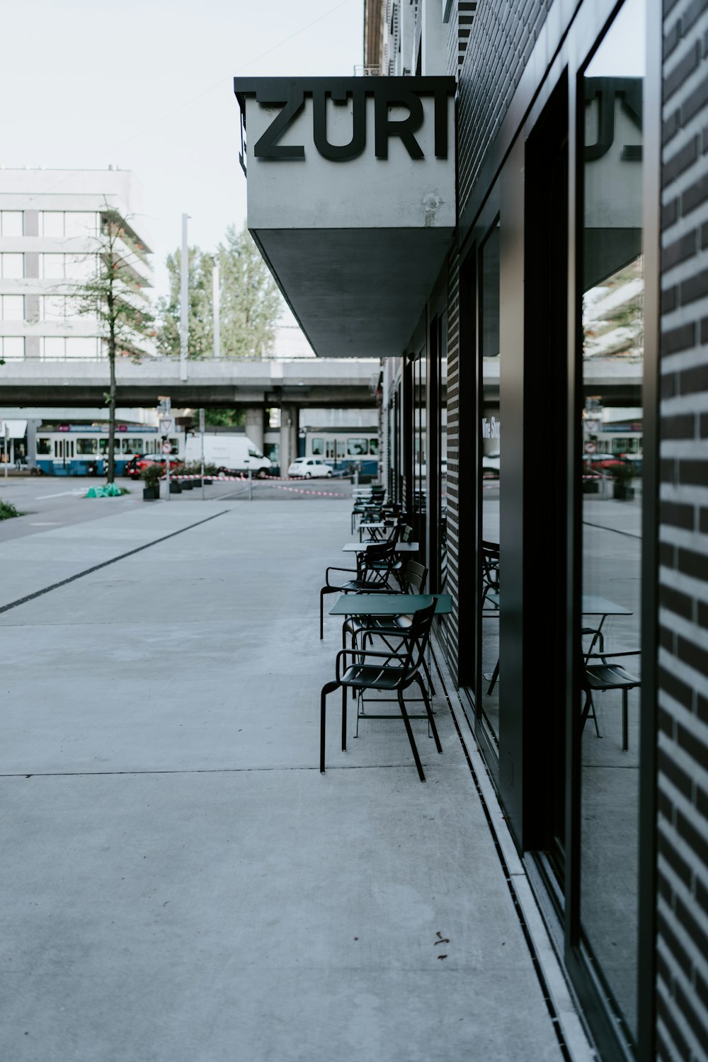 black metal chairs and tables near glass window building during daytime