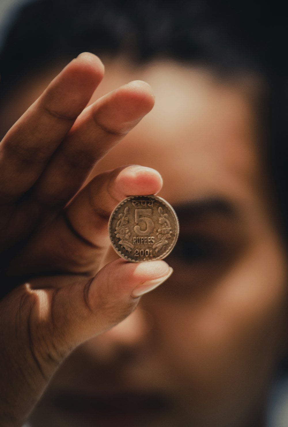 person holding silver round coin