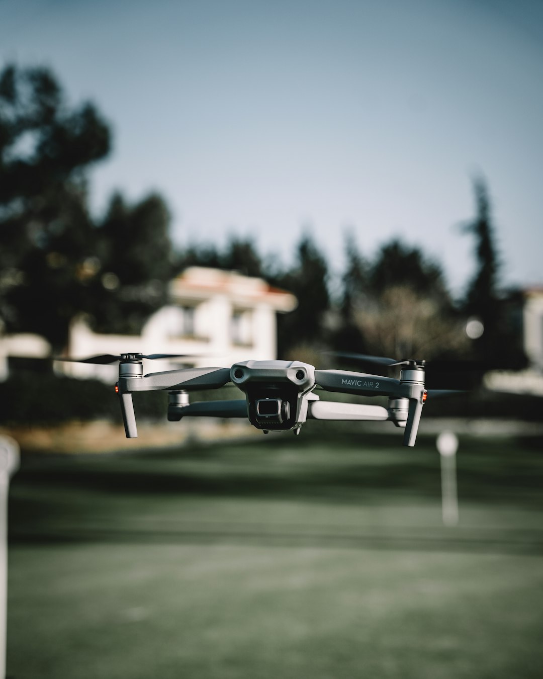 gray drone flying over green trees during daytime