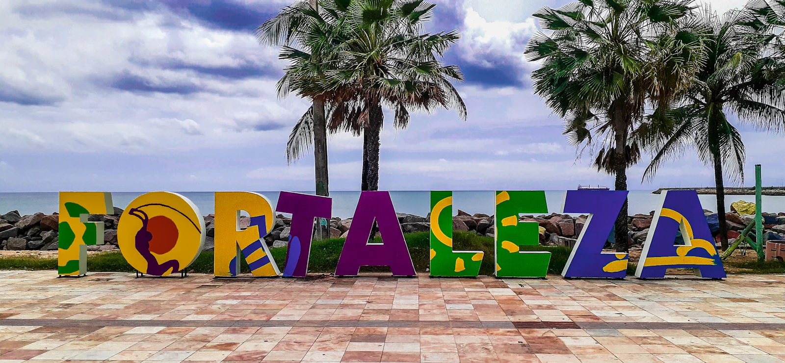 The letters spelling Fortaleza on the Beira Mar promenade, between the palms