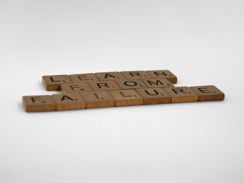 brown wooden letter blocks on white surface