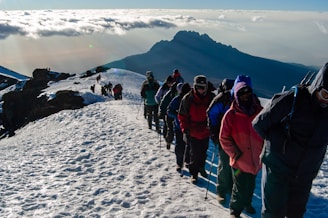 people in blue and red jacket standing on snow covered ground during daytime
