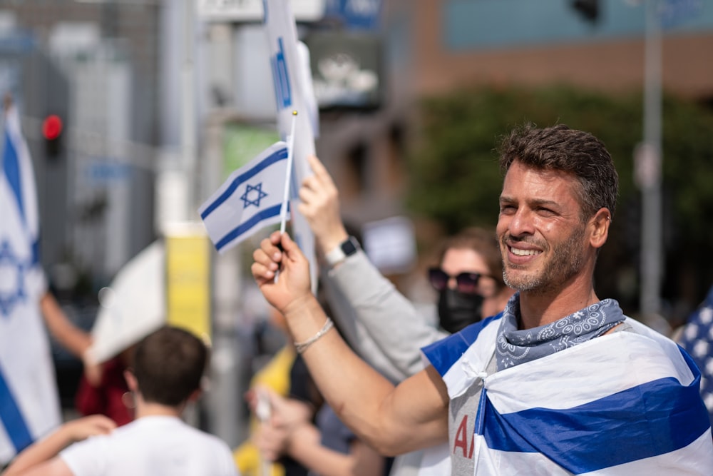 uomo in blu e bianco girocollo t-shirt che tiene giocattolo di plastica bianco e blu